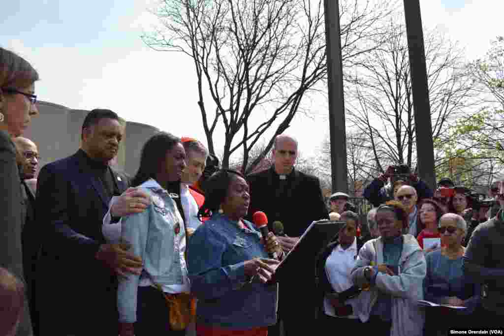 Family members of those who died in shootings are consoled by rights activist Rev. Jesse Jackson (left) and Chicago Archdiocese Cardinal Blase Cupich (right) as they read from a long list of homicide victims killed since the first of the year. The march w