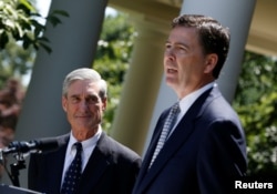 FILE - James Comey, right, a Republican who served in President George W. Bush's Justice Department, speaks alongside outgoing FBI Director Robert Mueller in the Rose Garden of the White House in Washington, June 21, 2013.