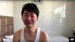 In this image from video taken Feb. 4, 2020 and released by Chen Qiushi, Chinese citizen journalist Chen Qiushi speaks in front of a convention center-turned makeshift hospital amid a viral epidemic in Wuhan in central China's Hubei province. (Courtesy of