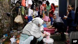 Afghan women wash and dry their clothes in Piraeus, near Athens, March 8, 2016. European Union leaders said they reached the outlines for a possible deal with Ankara to return thousands of migrants to Turkey early Tuesday.
