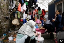 Afghan women wash and dry their clothes in Piraeus, near Athens, March 8, 2016. European Union leaders said they reached the outlines for a possible deal with Ankara to return thousands of migrants to Turkey early Tuesday.