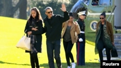 Tổng thống Mỹ Barack Obama vẫy chào khi ông đi cùng Đệ nhất Phu nhân Michelle Obama (phải) và hai người con gái của họ là Malia (trái) và Sasha trên Bãi Cỏ Nam Tòa Bạch Ốc, Washington, ngày 3 tháng 1, 2016. 