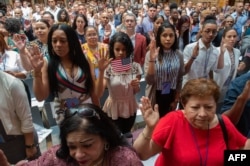 People take the oath as the US Citizenship and Immigration Services welcomes 200 new citizens from nearly 50 countries during a ceremony in honor of Independence Day at the New York Public Library, July 3, 2018, in New York.