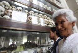FILE: A woman cries in front of the skulls and bones of more than 8,000 victims of the Khmer Rouge regime during a Buddhist ceremony at Choeung Ek, a "Killing Fields" site located on the outskirts of Phnom Penh, Cambodia, April 17, 2015.