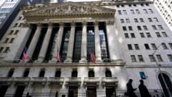 FILE - People walk past the New York Stock Exchange in New York's Financial District, on March 23, 2021.