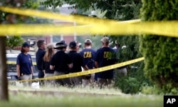 Investigators confer before looking for evidence around the baseball field in Alexandria, Virginia, June 14, 2017, that was the scene of a shooting involving House Majority Whip Steve Scalise, and others.,