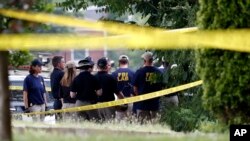 Investigators confer before looking for evidence around the baseball field in Alexandria, Virginia, June 14, 2017, that was the scene of a shooting involving House Majority Whip Steve Scalise, and others, during Congressional baseball practice.