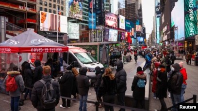 Decenas de personas hacen fila en Times Square, Nueva York, para someterse a una prueba de detección de la variante ómicron del COVID-19, el 19 de diciembre de 2021.