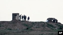 Fighters of People's Protection Units, or YPG, gather at their outpost west of the city of Kobani, northern Syria, Dec. 18, 2018.