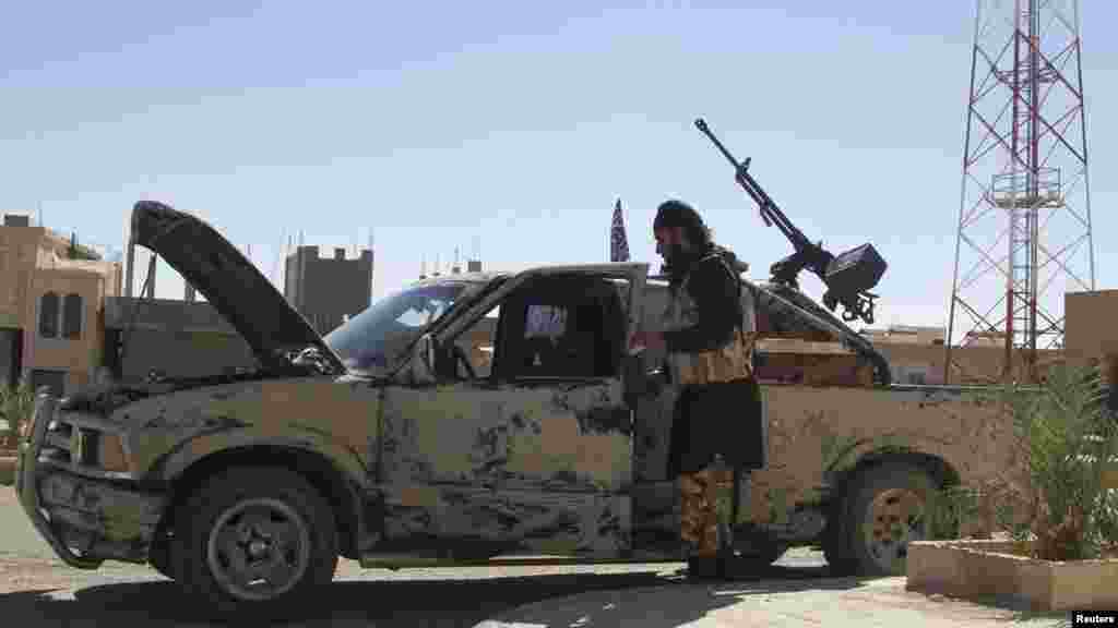 A Free Syrian Army fighter is seen near a vehicle mounted with an anti-aircraft weapon in Al-Sukhna in Homs province, Oct. 20, 2013.