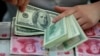 资料照：一名银行职员在安徽省一家银行里点数美元。