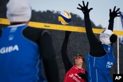 FILE - Austria's Stefanie Schwaiger, center, scores past China's Xue Chen during a snow volleyball exhibition match at the Austria House in Pyeongchang, South Korea, Feb. 14, 2018.