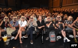 FILE - Actress Charlize Theron, center, attends the "Atomic Blonde" San Diego Comic-Con Fan Screening in San Diego, California, July 22, 2017.