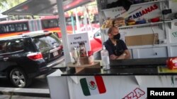 Fernando Peña Ramírez, de 53 años, exdiputado a la Asamblea Nacional de Venezuela, quien vive en México desde hace 6 años luego de exiliarse en el país, espera clientes en su puesto de comida venezolana en el centro de la Ciudad de México, México, el 11 de noviembre de 2021. 