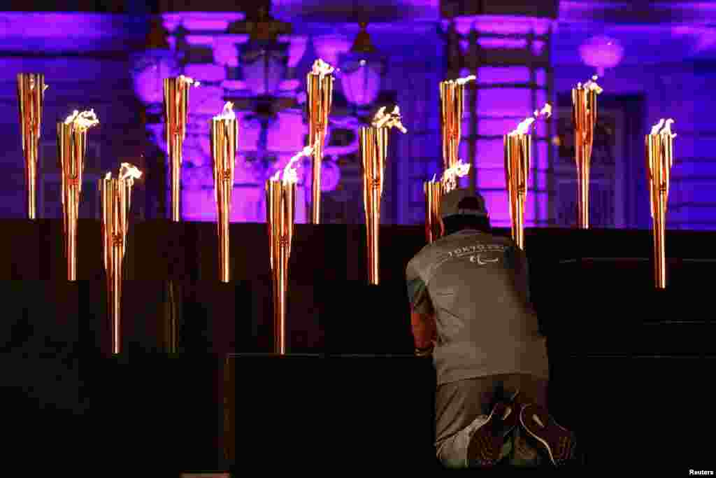 A man places a flame representing one of Japan&#39;s prefectures during the Tokyo 2020 Paralympic flame lighting ceremony at the state guest house in Tokyo, Japan.