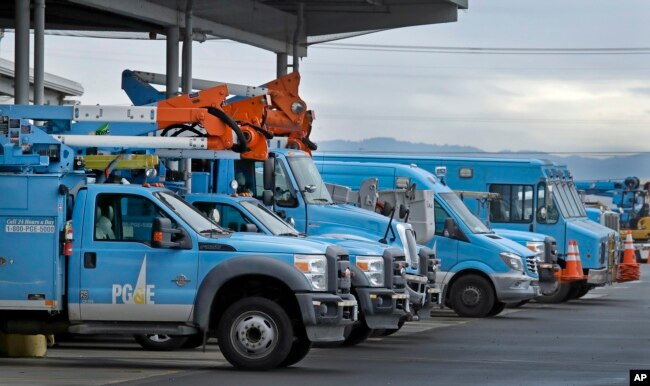 FILE - Pacific Gas & Electric vehicles are parked at the PG&E Oakland Service Center in Oakland, Calif., Jan. 14, 2019. The year's first fire danger warning in Northern California is putting Pacific Gas & Electric on alert. The utility said starting Saturday, it might turn off power to thousands of customers in areas north of San Francisco and in the Sierra foothills to help reduce the risk of fire.