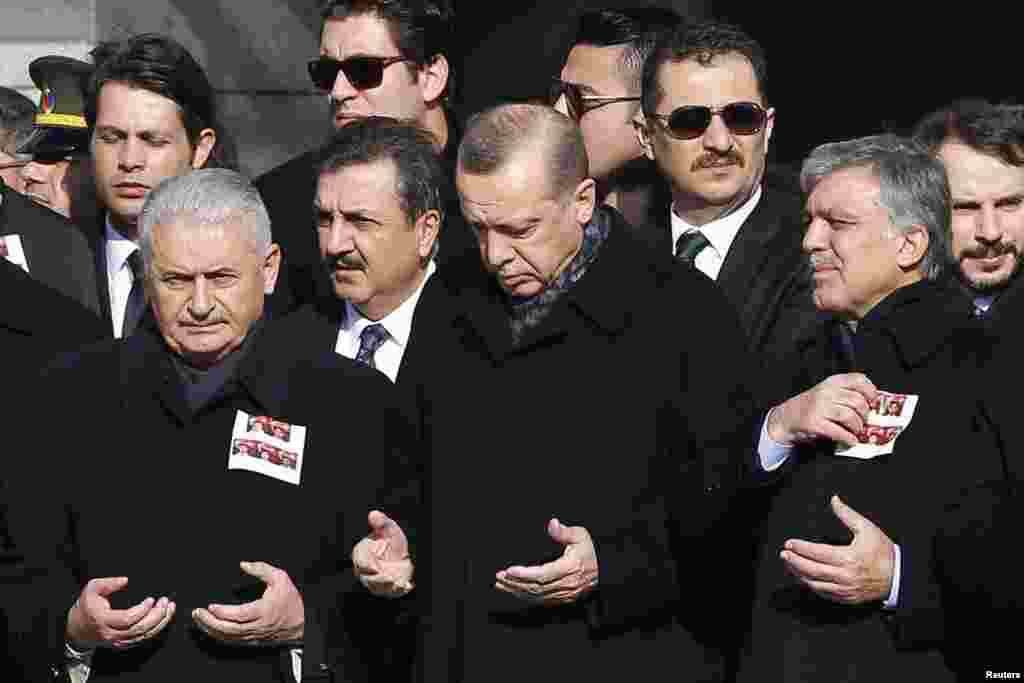 Turkish Prime Minister Binali Yildirim, President Tayyip Erdogan and former President Abdullah Gul pray during a ceremony for police officers killed in Saturday&#39;s blasts in Istanbul, Dec. 11, 2016.