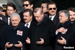 Turkish Prime Minister Binali Yildirim, President Tayyip Erdogan and Former President Abdullah Gul pray during a ceremony for police officers killed in Saturday's blasts in Istanbul, Dec. 11, 2016.