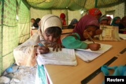 Displaced Yemeni students attend a class in a tent at a refugee camp located between Marib and Sanaa, Yemen, March 29, 2018.