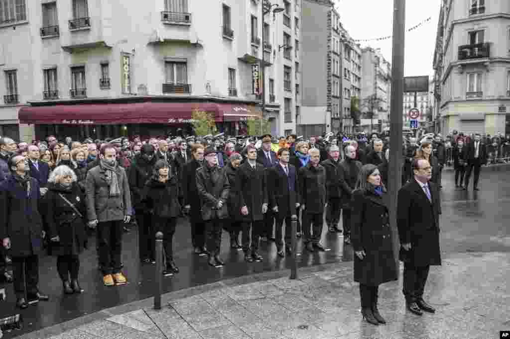 Presiden Perancis Francois Hollande dan Walikota Paris Anne Hidalgo melakukan sikap sempurna setelah membuka plakat peringatan dekat kafe Petit Cambodge dan Carillon di Paris, dalam upacara mengenang para korban dalam serangan di kota itu tahun lalu (13/11).