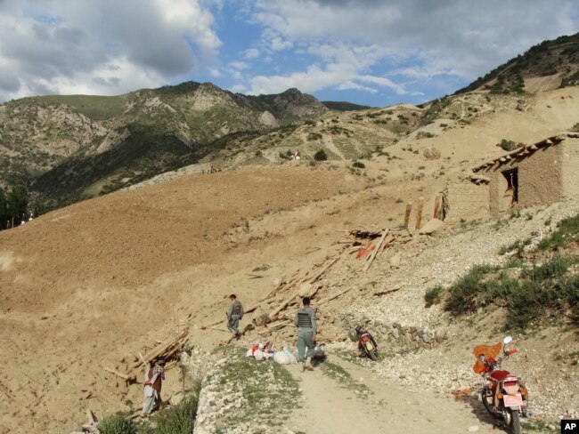 Polisi nasional Afghanistan berdiri di lokasi setelah gempa bumi melanda Provinsi Baghlan, utara Kabul, Afghanistan, Senin, 11 Juni 2012. (Foto: AFP)...