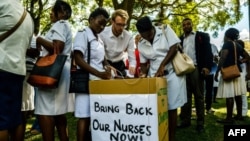 FILE: People cast their letters of complaint to Zimbabwe deputy President Chiwenga among nurses who had gathered at Unity Square in Harare on April 20, 2018 to demonstrate their discontent in a #BringBackOurNurses campaign after being summarily dismissed by Zimbabwe Vice President Constantino Chiwenga. / AFP PHOTO /