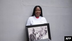 Toyin Lolu-Ogunmade, the founder of the agency Precious Conceptions, which helps women with fertility problems, poses with a picture of her family in the backyard of her office in Lagos on December 12, 2018.