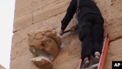 A militant hammers at a sculpted face in the ancient Iraqi city of Hatra in this scene from an Islamic State militant video posted on YouTube, April 3, 2015. The fortified city is recognized as a UNESCO World Heritage site. 