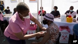 Seorang pasien menerima vaksin Johnson & Johnson di pusat vaksinasi pop-up, di pangkalan taksi Bare di Soweto, Afrika Selatan, Jumat, 20 Agustus 2021. (Foto: AP)
