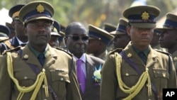 Zimbabwean President Robert Mugabe (C) inspects the honor guard during a police parade in Harare, June 13, 2013.
