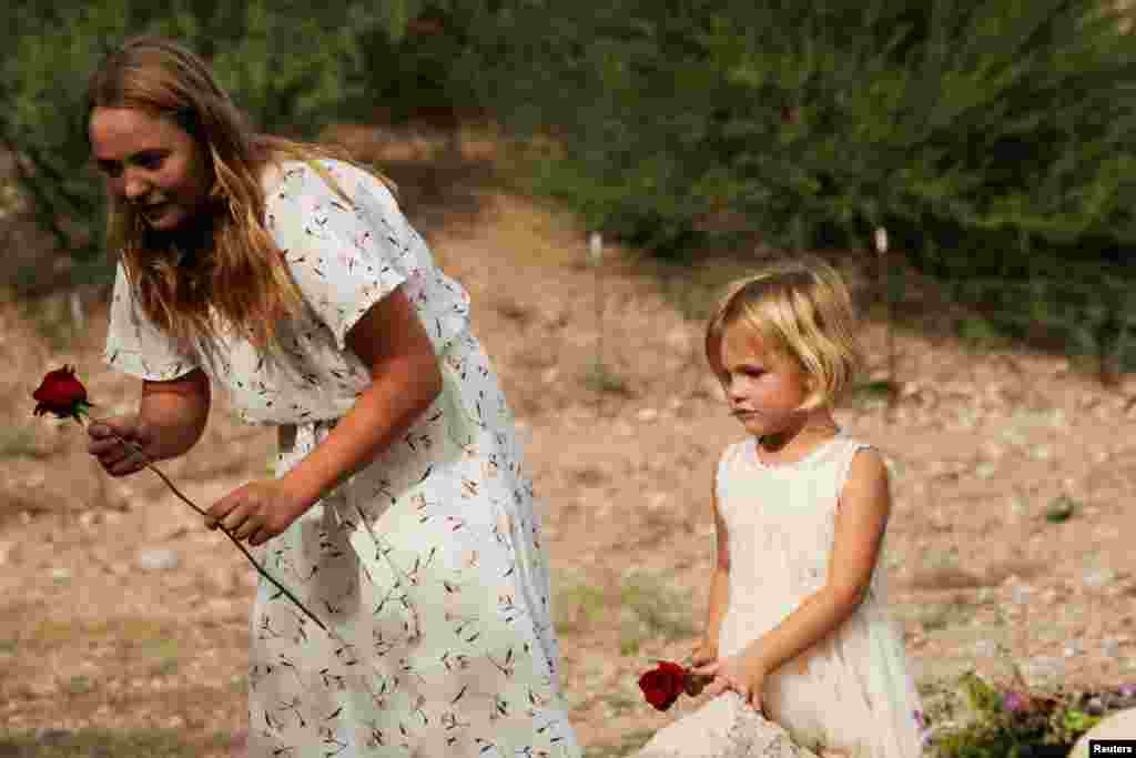 Una niña sostiene una flor durante el funeral de Dawna Ray Langford y sus hijos Trevor, Rogan.