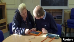 Teacher at Prior's Court school in Berkshire, England uses a table to record data