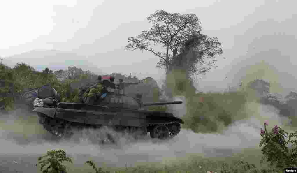 A Congolese armed forces (FARDC) tank fires a shot as soldiers battle M23 rebels in Kibati, outside Goma in the eastern Democratic Republic of Congo.
