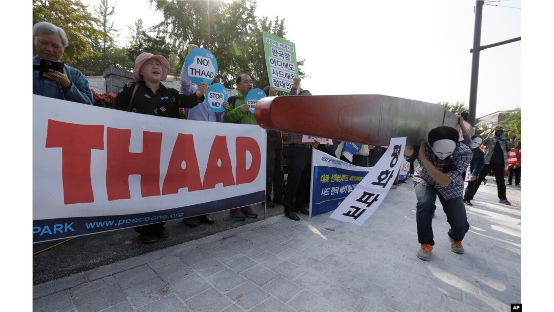 Protesters carry a mock missile symbolizing an advanced U.S. missile defense system called Terminal High-Altitude Area Defense, or THAAD, during a rally to oppose a plan to deploy the THAAD in front of the Defense Ministry in Seoul, South Korea, Oct. 20, 2016.
