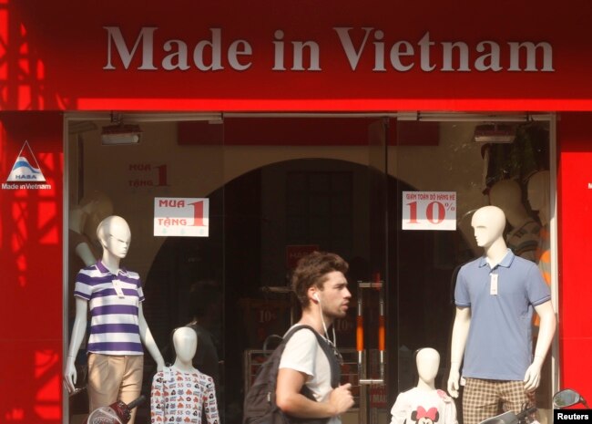 FILE - A tourist walks past a clothes shop in Hano,i October 3, 2014.