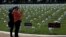 Visitors take pictures of the new Gun Violence Memorial, an installation featuring 38,000 silk white roses in 4,000 vases to commemorate the roughly 40,000 Americans who die annually in gun violence, on the National Mall in Washington, D.C.