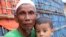 A Rohingya refugee sits with a child at the Kutupalong Rohingya refugee camp in Cox's Bazar, Bangladesh, June 2, 2020. 