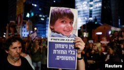 FILE —A person holds a banner with a picture during a protest calling for the immediate release of hostages held in Gaza who were seized from southern Israel on October 7 by Hamas gunmen during a deadly attack, in Tel Aviv, Israel, November 18, 2023. 