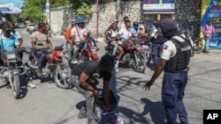 Police officers man a checkpoint checking for weapons, in the Petion-Ville of Port-au-Prince, Haiti, Tuesday, Nov. 19, 2024. 