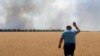 A farmer reacts as he looks at his burning field caused by the fighting at the front line in the Dnipropetrovsk region, Ukraine, Monday, July 4, 2022. (Efrem Lukatsky/AP)