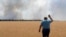 A farmer reacts as he looks at his burning field caused by the fighting at the front line in the Dnipropetrovsk region, Ukraine, Monday, July 4, 2022. (Efrem Lukatsky/AP)