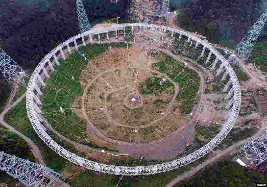 A 500-meter aperture spherical telescope (FAST) is seen in construction in Pingtang county, Guizhou province, July 28, 2015. According to local media, the telescope will be put into use by September, 2016, and will become the largest in the world. China invested 667 million yuan in the construction and the site selection took 15 years. &nbsp;