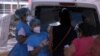 Trabajadores de la salud inoculan a mujeres con la vacuna AstraZeneca COVID-19, afuera del estadio de fútbol Rommel Fernández, en Ciudad de Panamá.