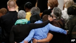 Para pelayat di Katedral Nasional di Washington saling merangkul saat berdoa untuk korban penembakan di Sandy Hook Elementary School di Newtown, Connecticut, 12 Desember 2013.