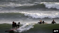 ARCHIVO - Deportistas practican surf en una playa de Lima, el 22 de octubre de 2020.