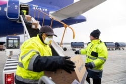 Workers unload boxes containing medical aid and protective materials to combat COVID-19 from a plane at Liszt Ferenc International Airport in Budapest, Hungary, March 23, 2020, after its arrival from Shanghai, China.