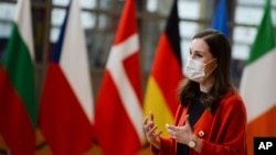 Finland's Prime Minister Sanna Marin speaks with the media as she arrives for an EU summit in Brussels, Oct. 16, 2020. 