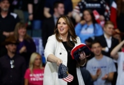 FILE - Republican National Committee Chairwoman Ronna McDaniel throws hats to the audience at a rally for President Donald Trump in Grand Rapids, Michigan, March 28, 2019.