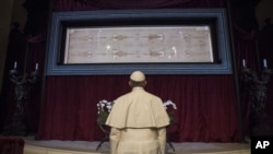 FILE - Pope Francis prays in front of the Holy Shroud of Turin, the 14 foot-long linen revered by Christians as the burial cloth of Jesus, on display at the Cathedral of Turin, Italy, June 21, 2015.