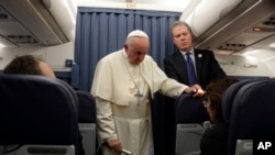 El papa Francisco, flanqueado por el portavoz del Vaticano Greg Burke, durante una conversación con los periodistas a bordo del avión que lo llevó a Roma tras dos días de visita a Irlanda el domingo, 26 de agosto de 2018.